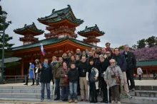 Photo de groupe de l'équipe Charmant entourée des 23 opticiens invités au sanctuaire Heian à Kyoto