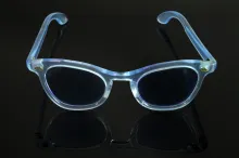 Paire de lunettes de MARLÈNE DIETRICH en acétate teinté bleu pâle, soulignée de rosaces en métal au niveau des charnières.