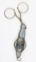 Binocles, argent, fin XVIIIe –début XIXe siècle, un portrait orne le manche très coloré ©Musée de la Lunette  - coll. Essilor-Pierre Marly. Photo : Pierre Guénat