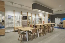 La table d’échanges, élément central du magasin, facilite la communication entre les personnes pour un choix monture collaboratif, plus facile et convivial.